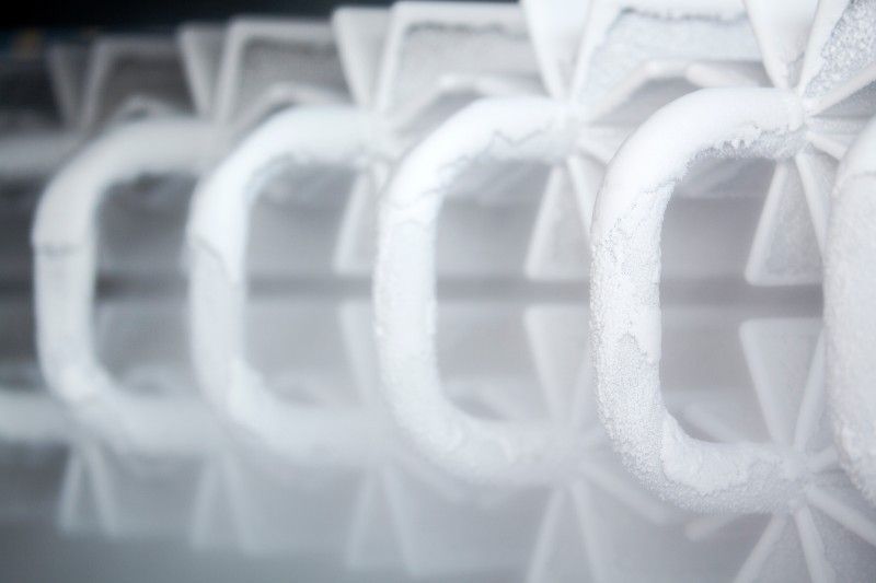 A close up of a row of ice cubes in a freezer.