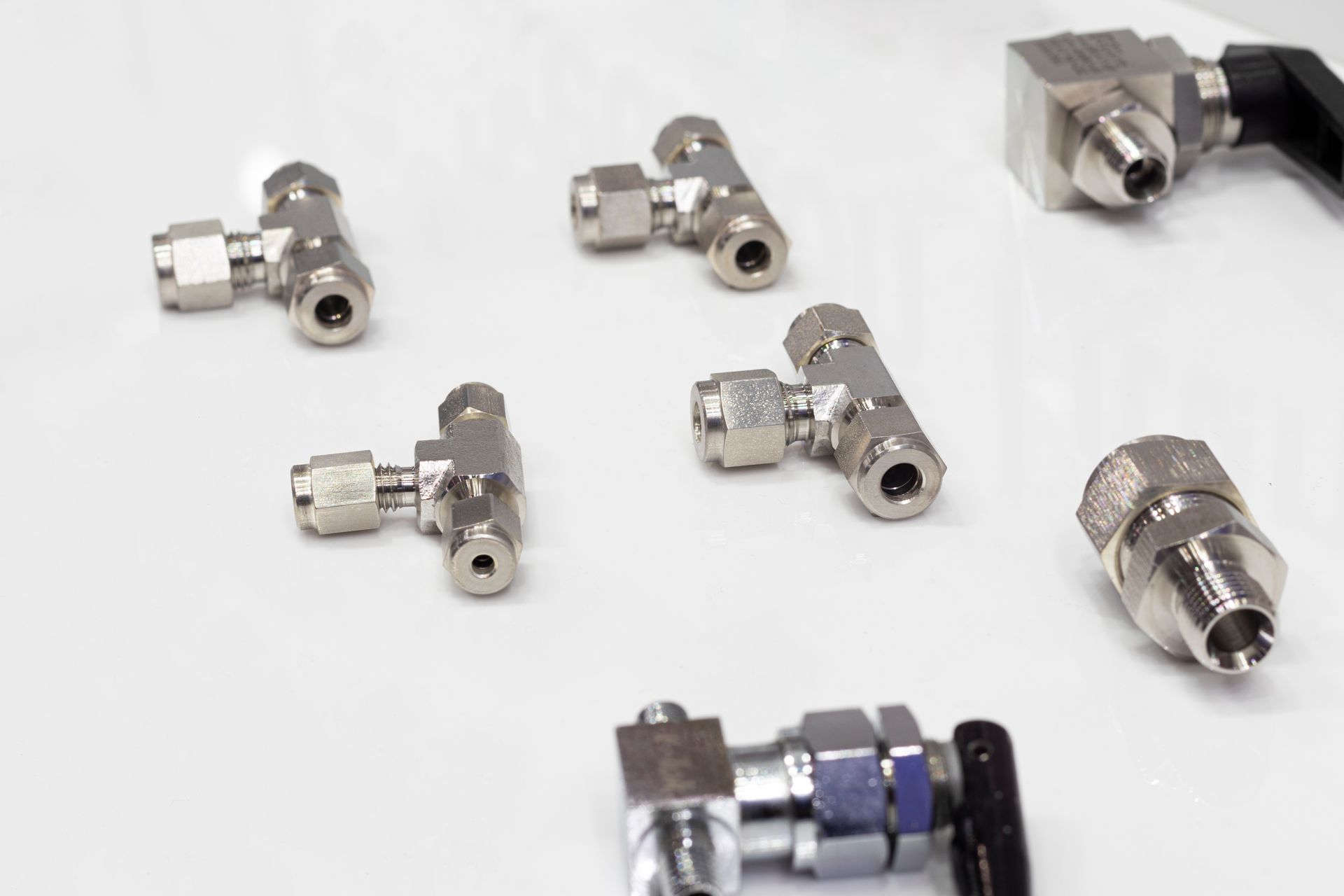 A group of metal fittings are sitting on a white surface.