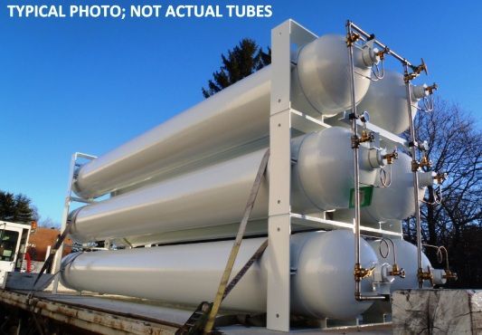 A  row of blue gas cylinders are connected to a pipe 