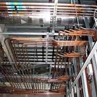 A bunch of pipes are hanging from the ceiling of a building.