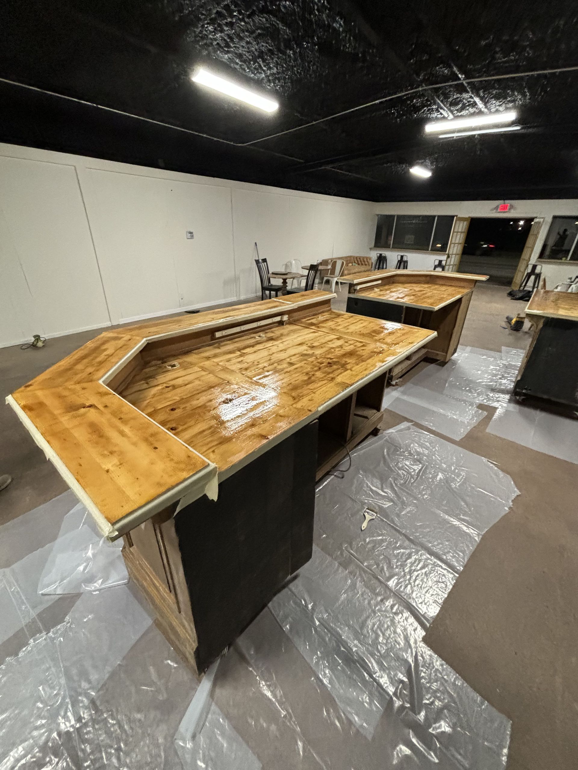 Wooden bar with a glossy finish in a large, empty room.