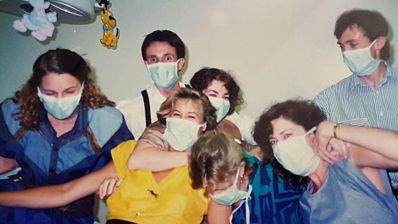 A group of people wearing face masks are posing for a picture.