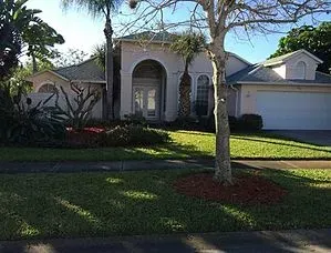 A large white house with a tree in front of it.