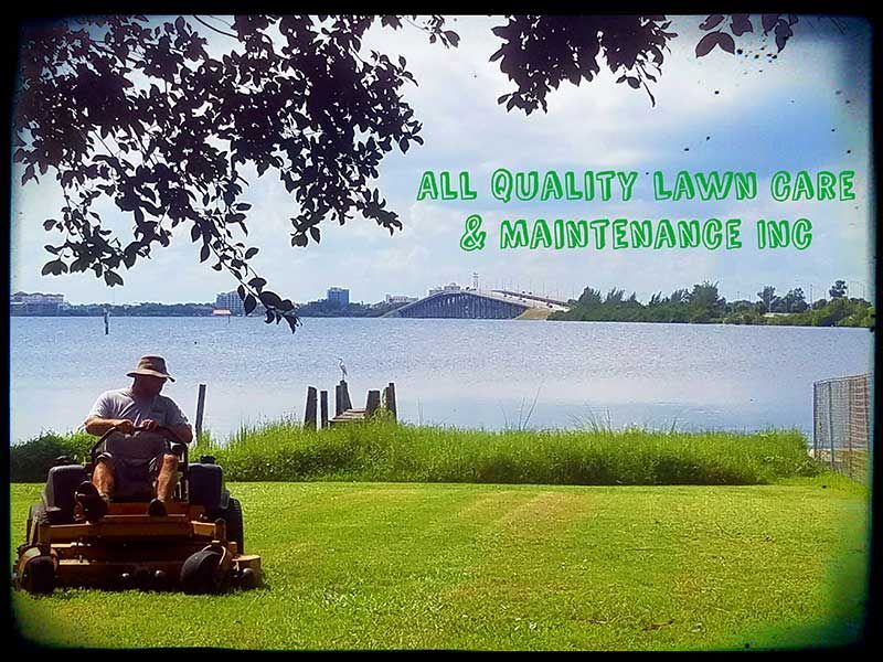 A man is riding a lawn mower in front of a body of water.