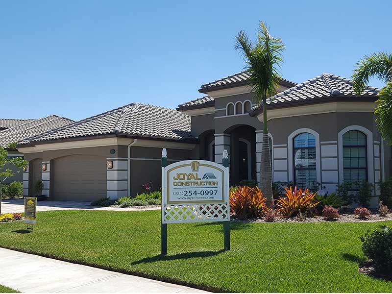 A house with a for sale sign in front of it.