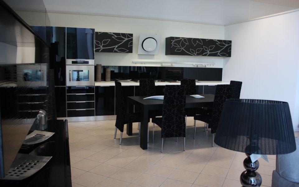 cucina con tavolo, sedie e pensili neri