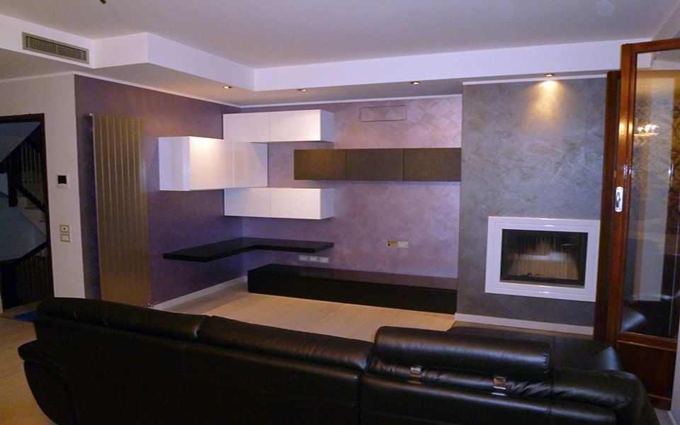 salotto con pensili sospesi e parete effetto spatolato