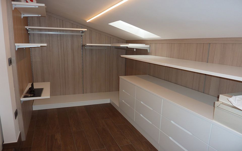 cabina armadio mansardata con mensole e cassettiera