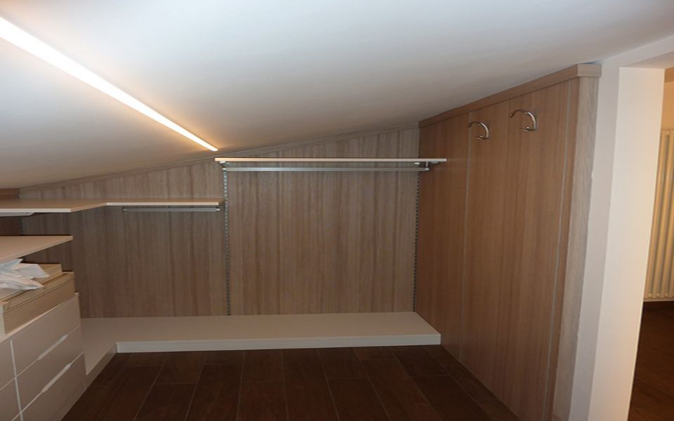 cabina armadio mansardata con mensole bianche