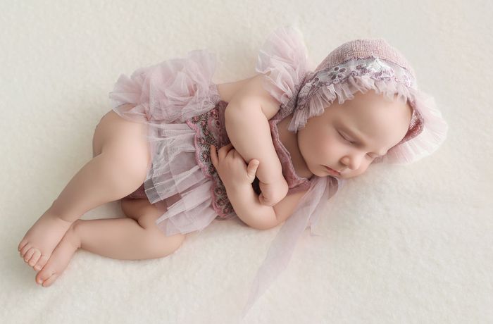 Sleeping newborn baby posed safely during a baby-led session by a certified newborn photographer in Mokena, Illinois.