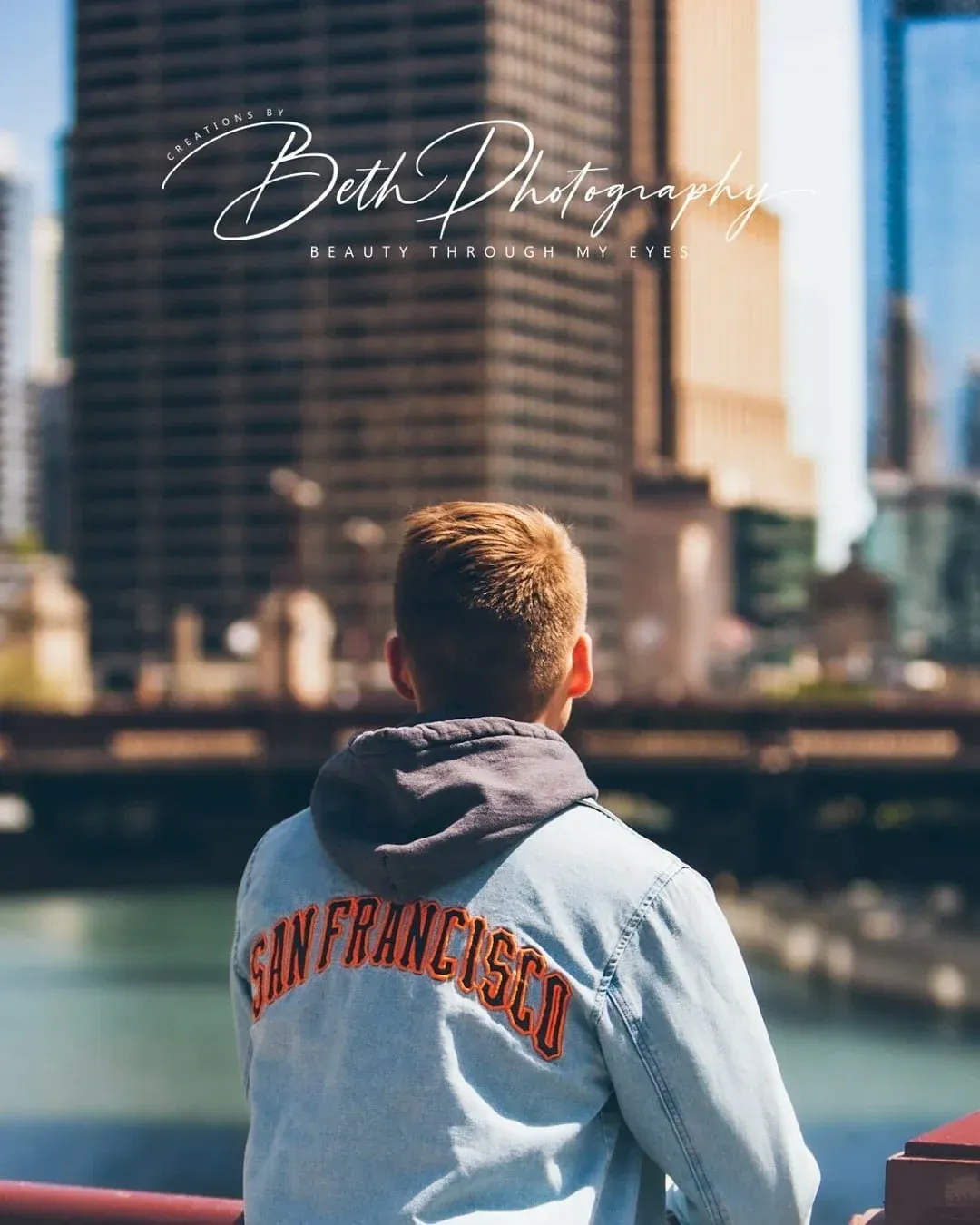 A man in a denim jacket with city view