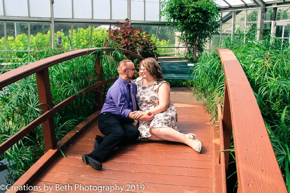 couple sitting on a wooden bridge