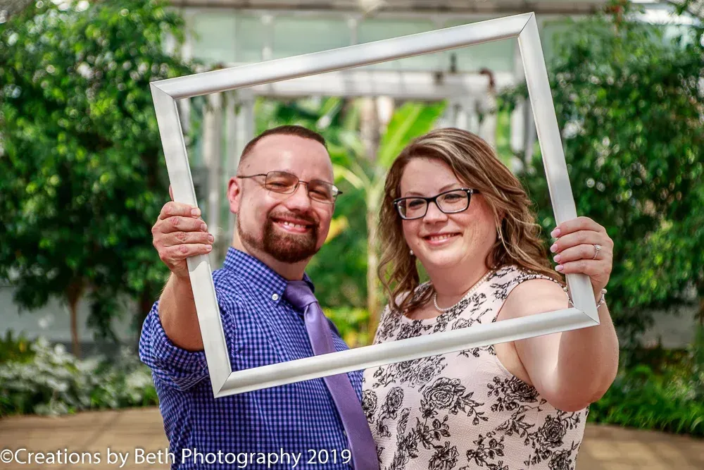 couple smiling in a white picture frame portrait