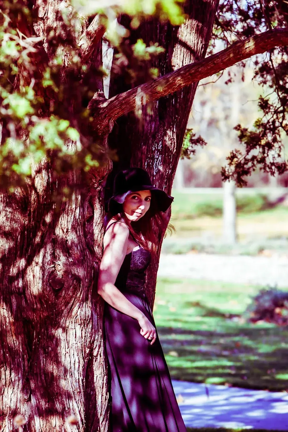 woman in a black dress with sunlit outdoor setting