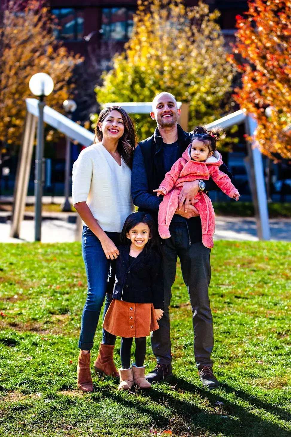A family is posing for a picture in a park.
