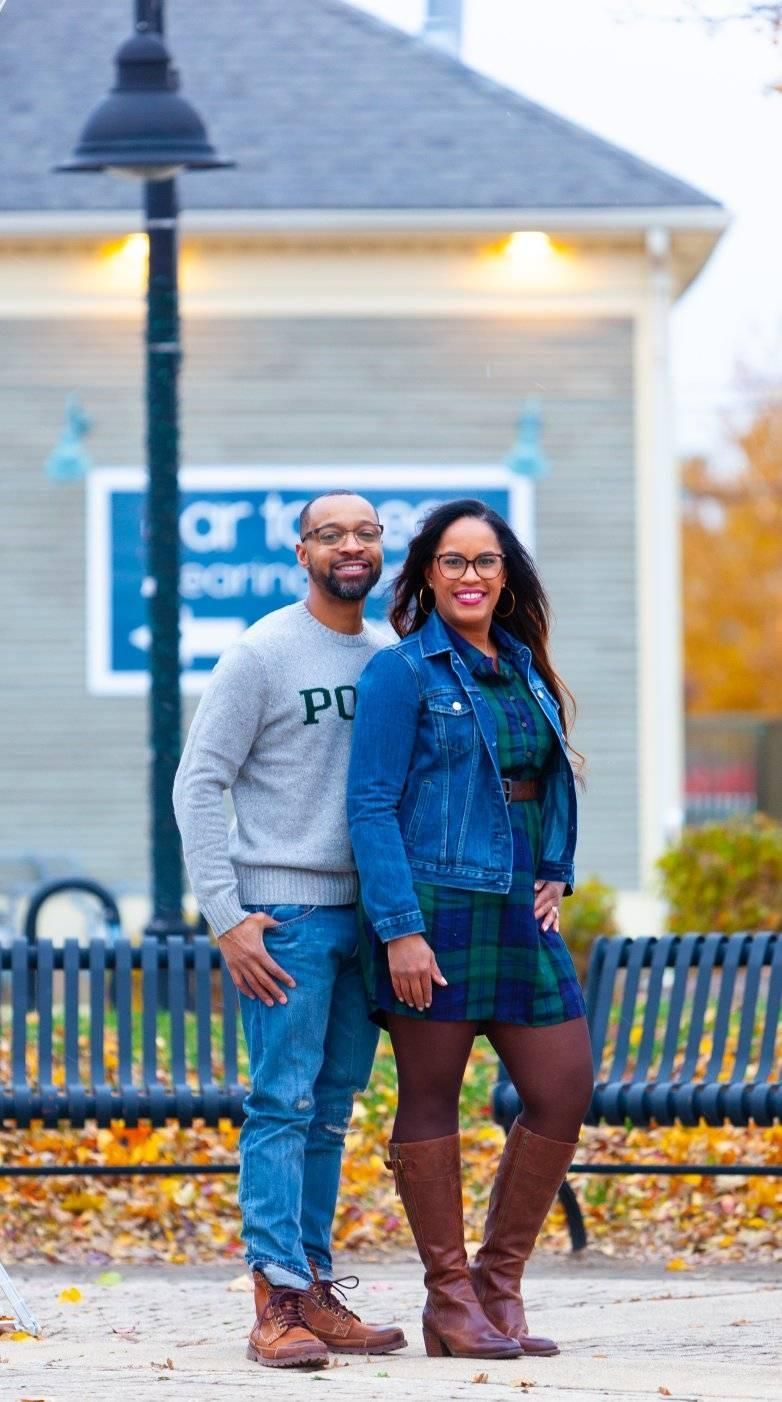 couple posing outdoors near a building and a lamppost