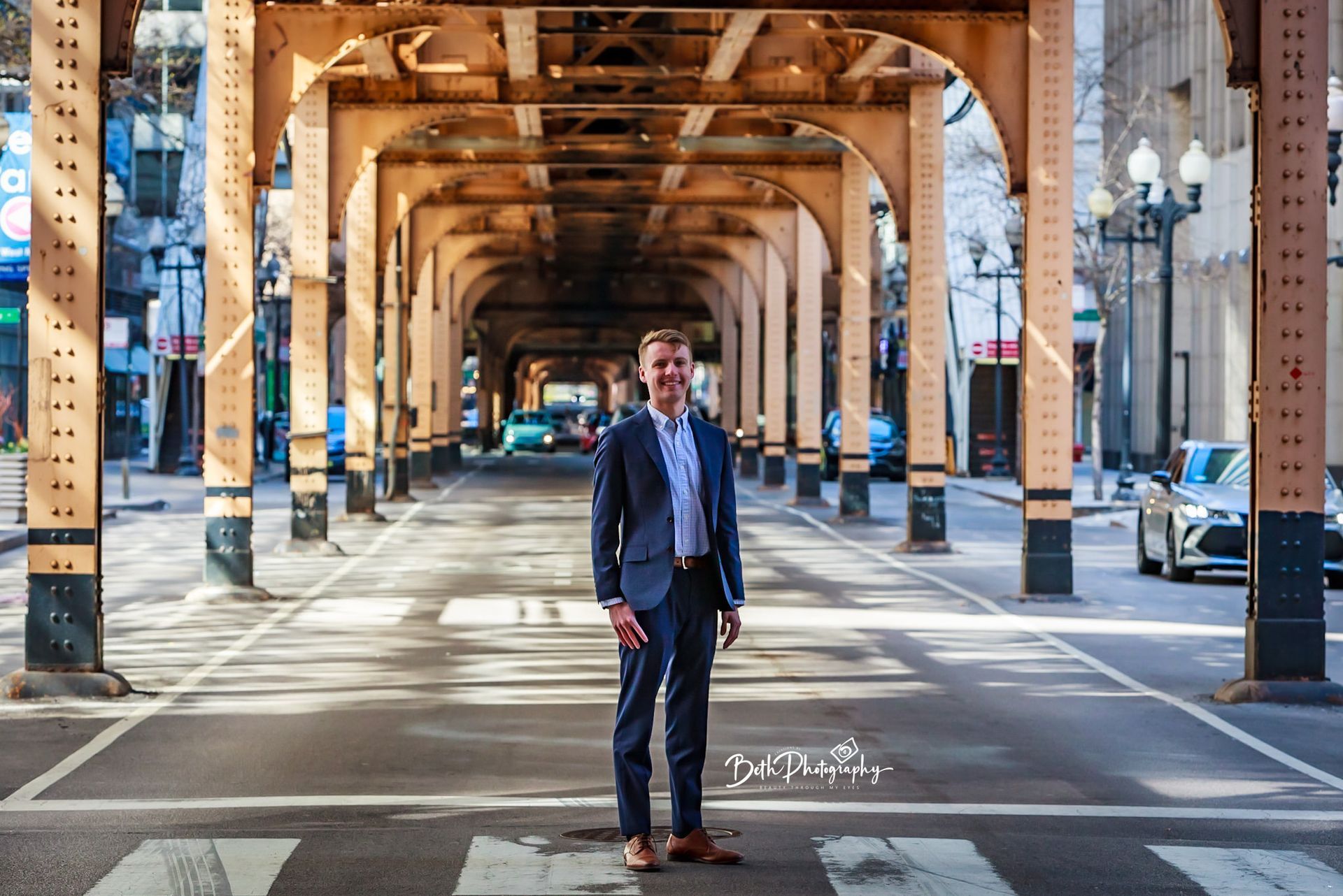 man in suit stands on a city street
