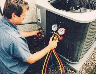 A man is working on an air conditioner with a bunch of gauges attached to it.