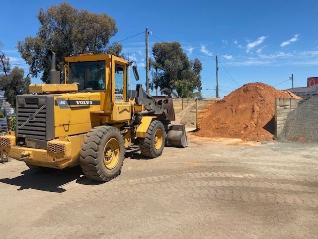 A Yellow Volvo Wheel Loader Is Parked In Front Of A Pile Of Dirt — DHM Sand, Gravel & Soil Supplies in Sebastopol, VIC
