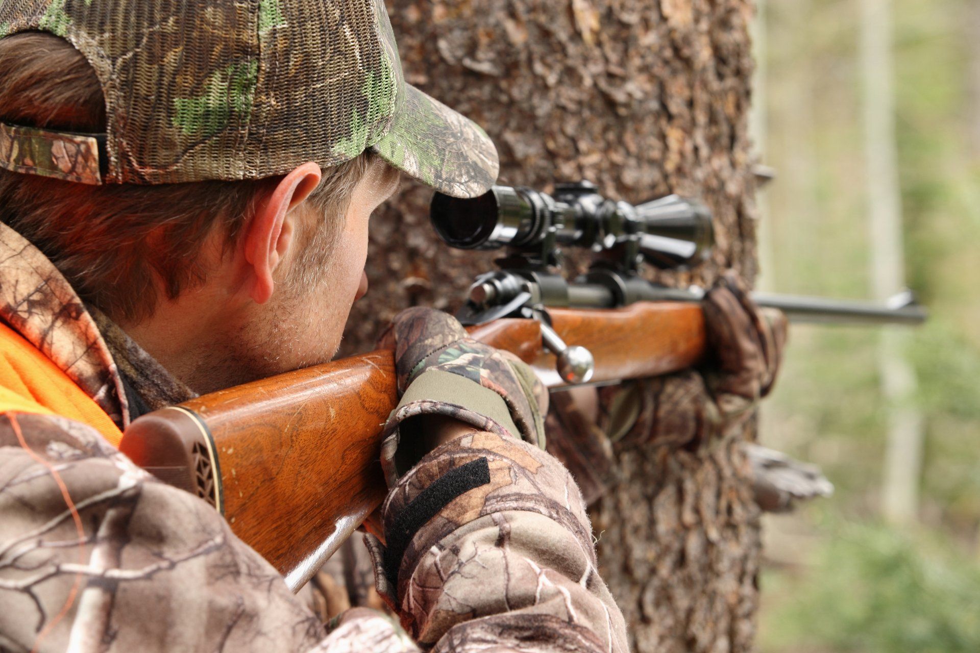 hunter aiming rifle in forest