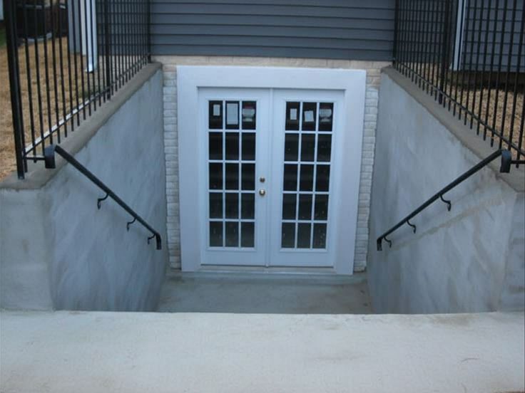 walkout basement entrance with double french doors at bottom of concrete stairwell
