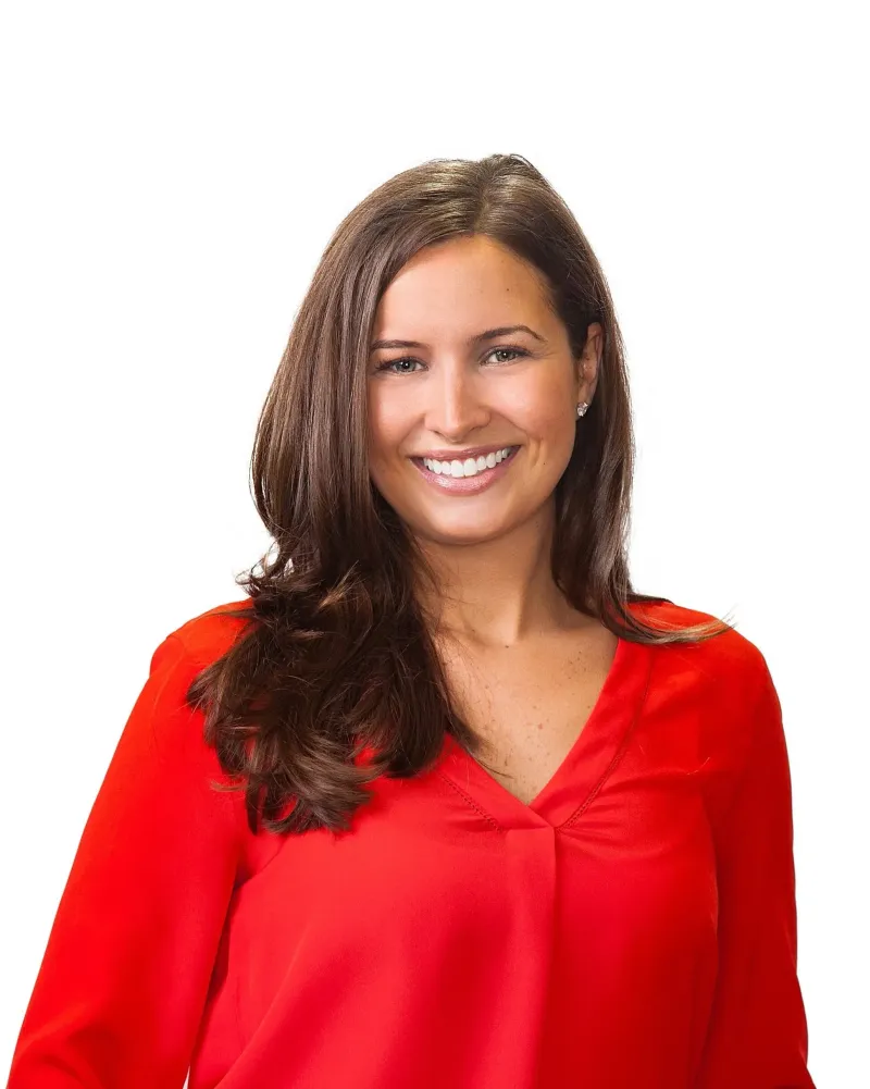 The woman is wearing a red shirt and smiling for the camera.