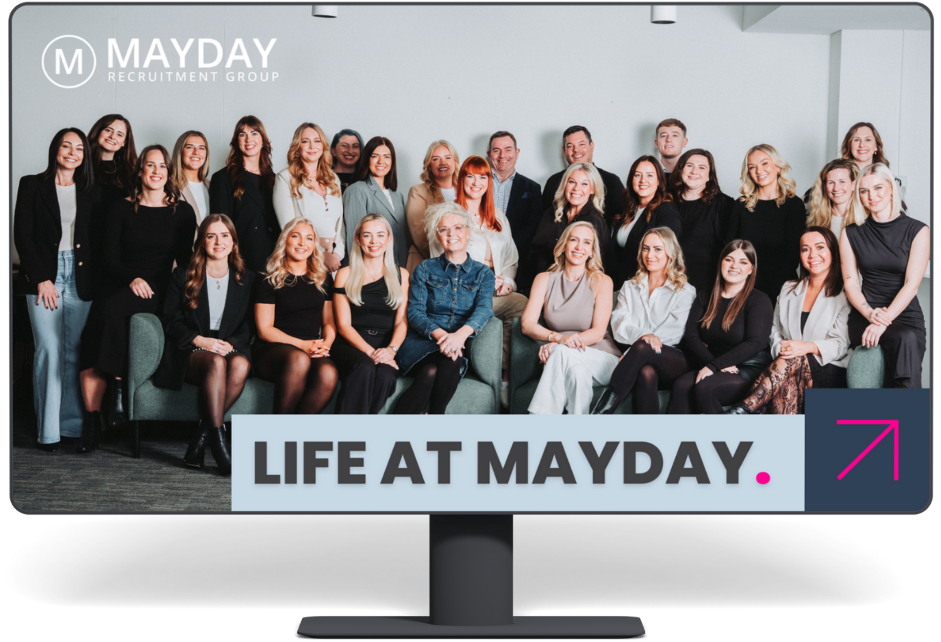 Group photo of Mayday Recruitment staff posing behind a banner reading 