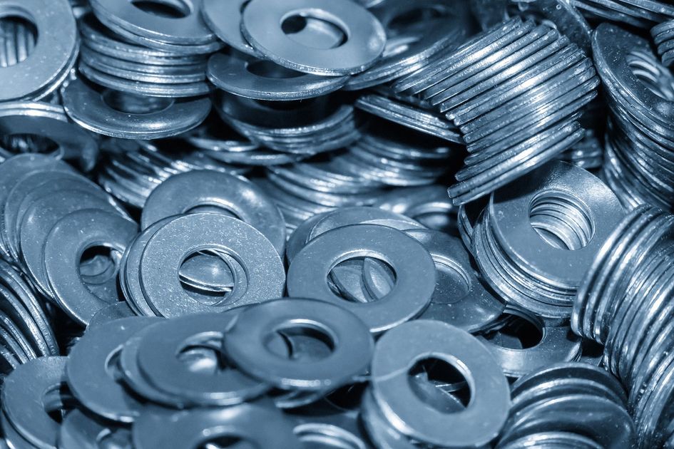 Arandelas de metal plateado apiladas y esparcidas juntas