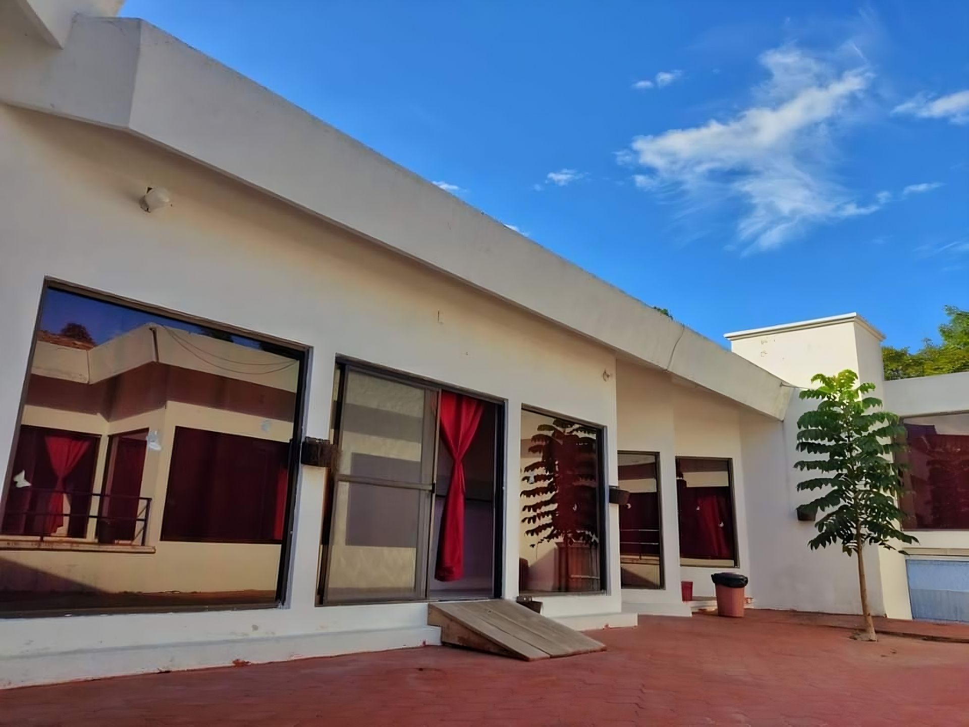 Una casa blanca con muchas ventanas y un árbol frente a ella.