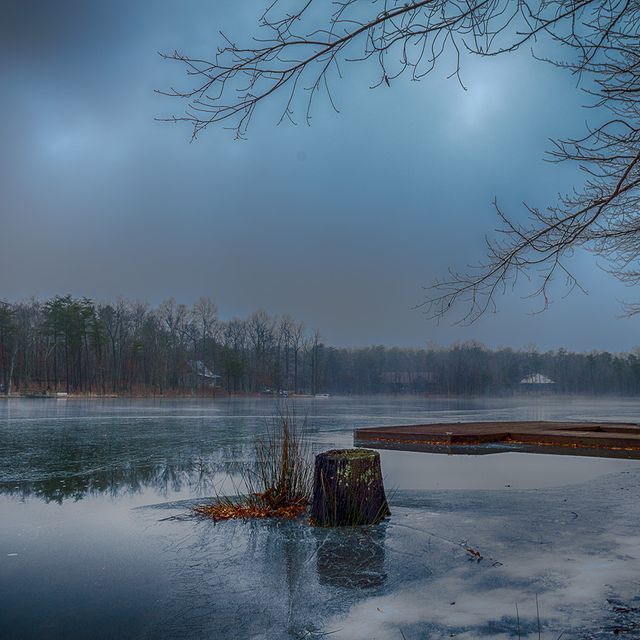 A frozen lake with a dock in the middle of it
