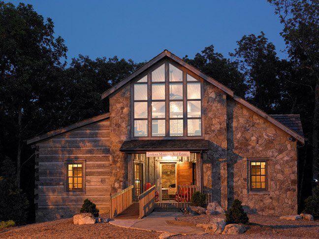 A large house with a lot of windows is lit up at night