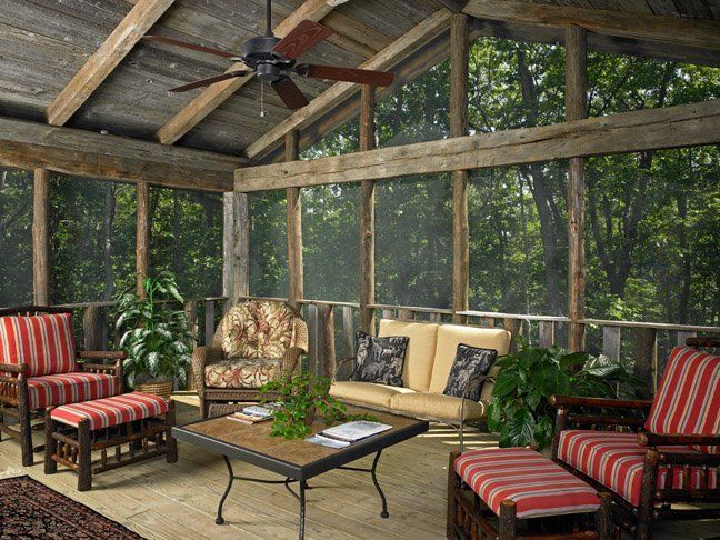 A screened in porch with furniture and a ceiling fan