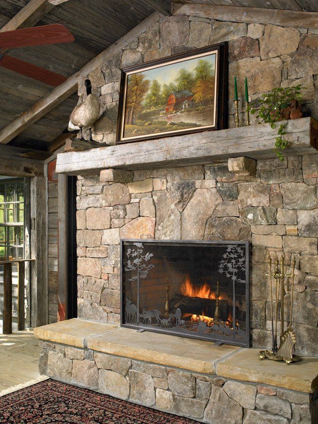 A stone fireplace with a painting above it