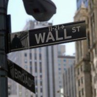 A street sign for wall street and broadway in new york city