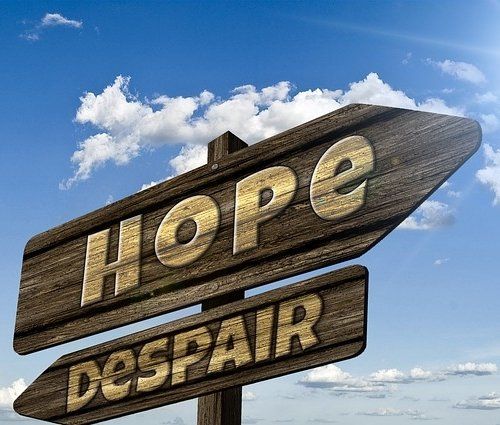 A wooden sign that says hope and despair on it