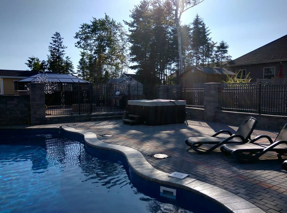 A swimming pool with a hot tub in the backyard