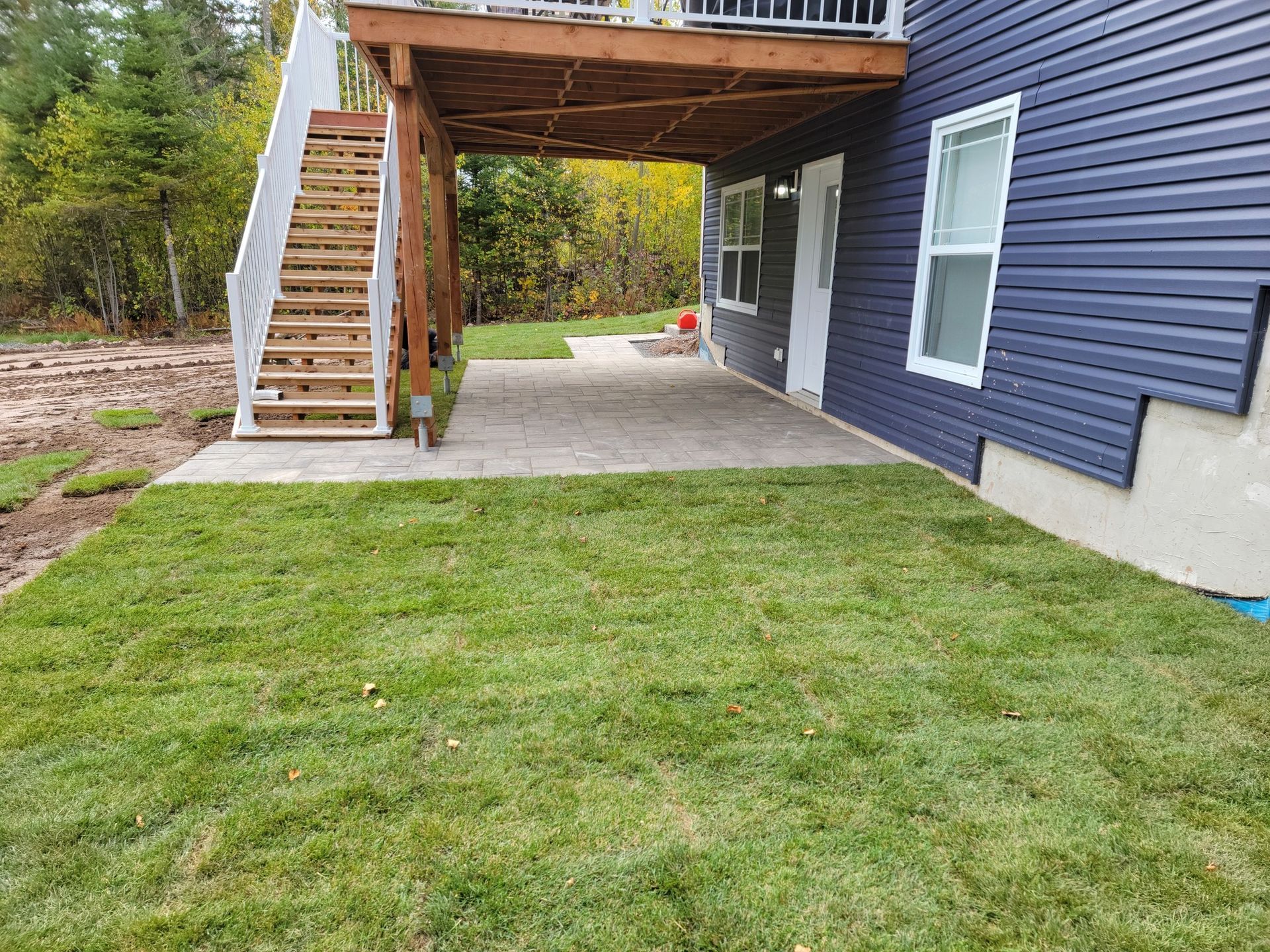 The backyard of a house with a deck and stairs.