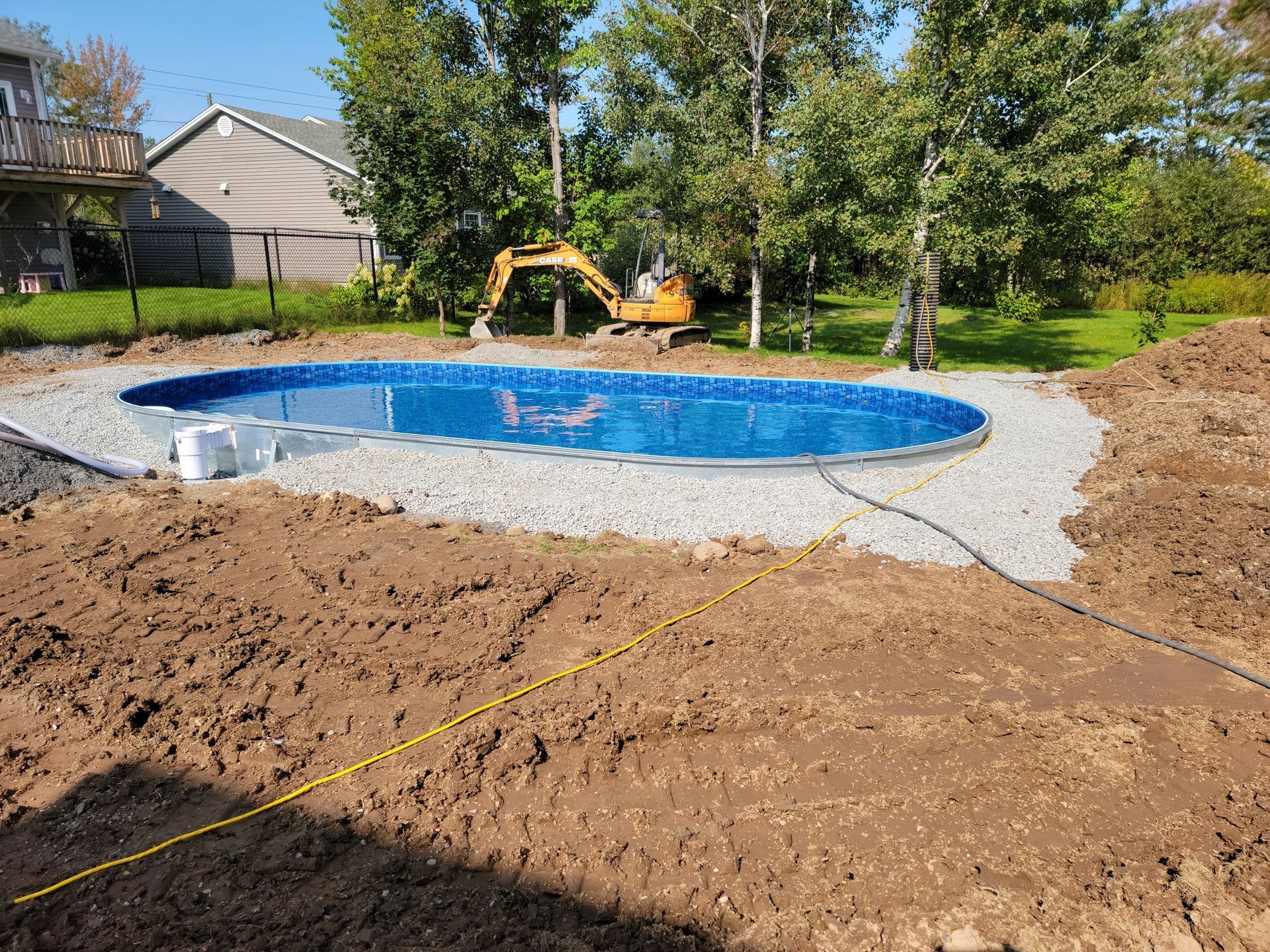 A large swimming pool is being built in a backyard.
