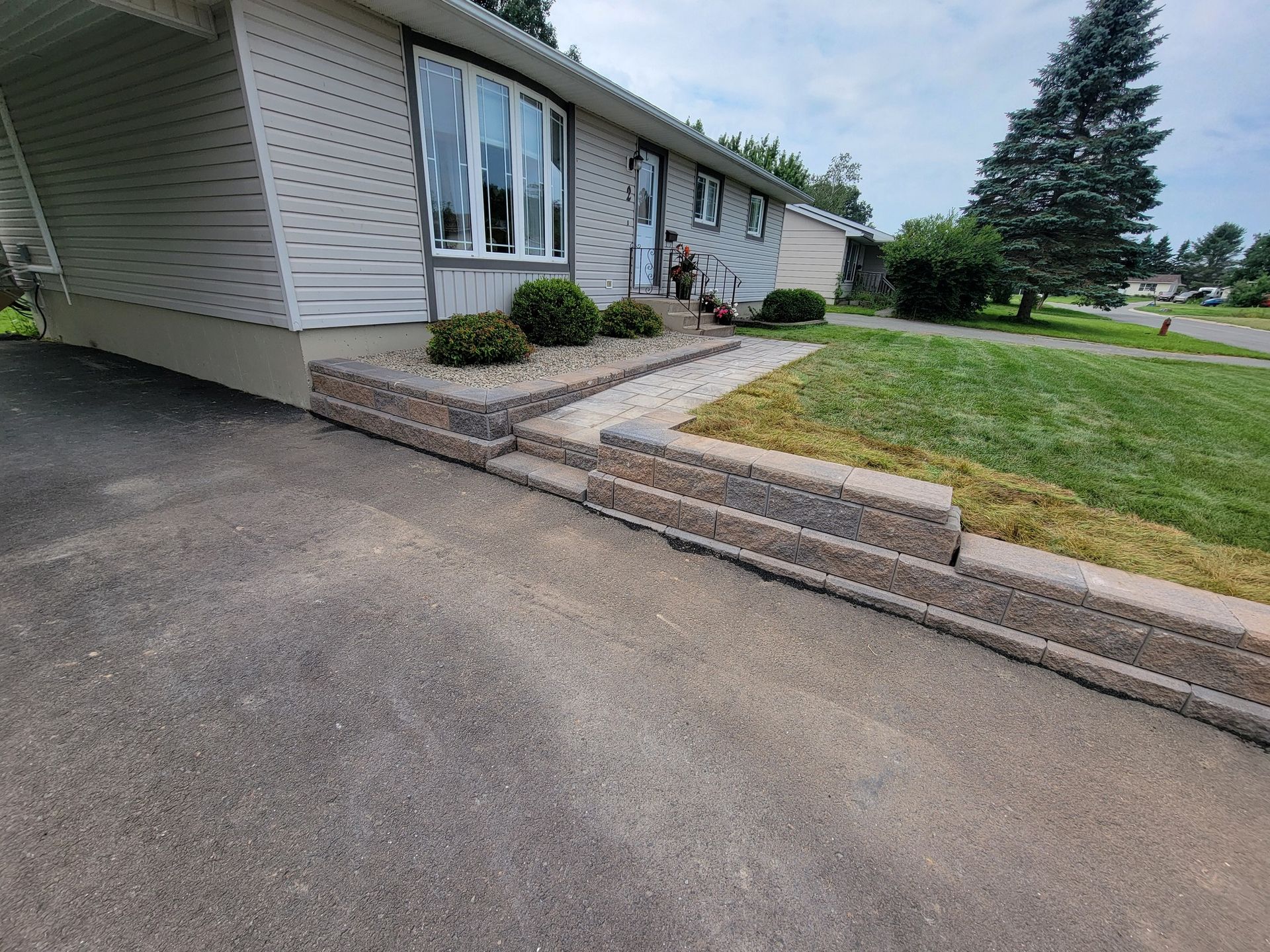A white house with a stone walkway leading to the front door.