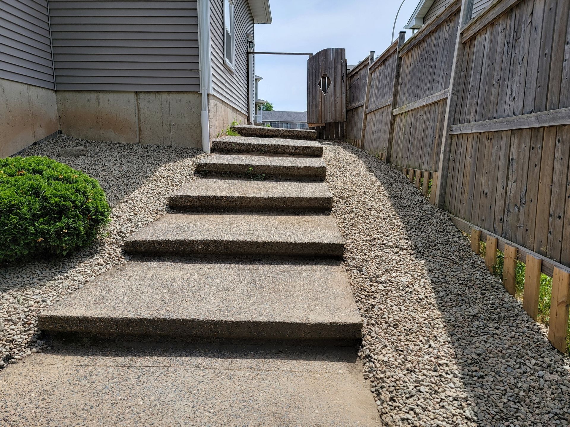 A concrete walkway with stairs leading up to a house