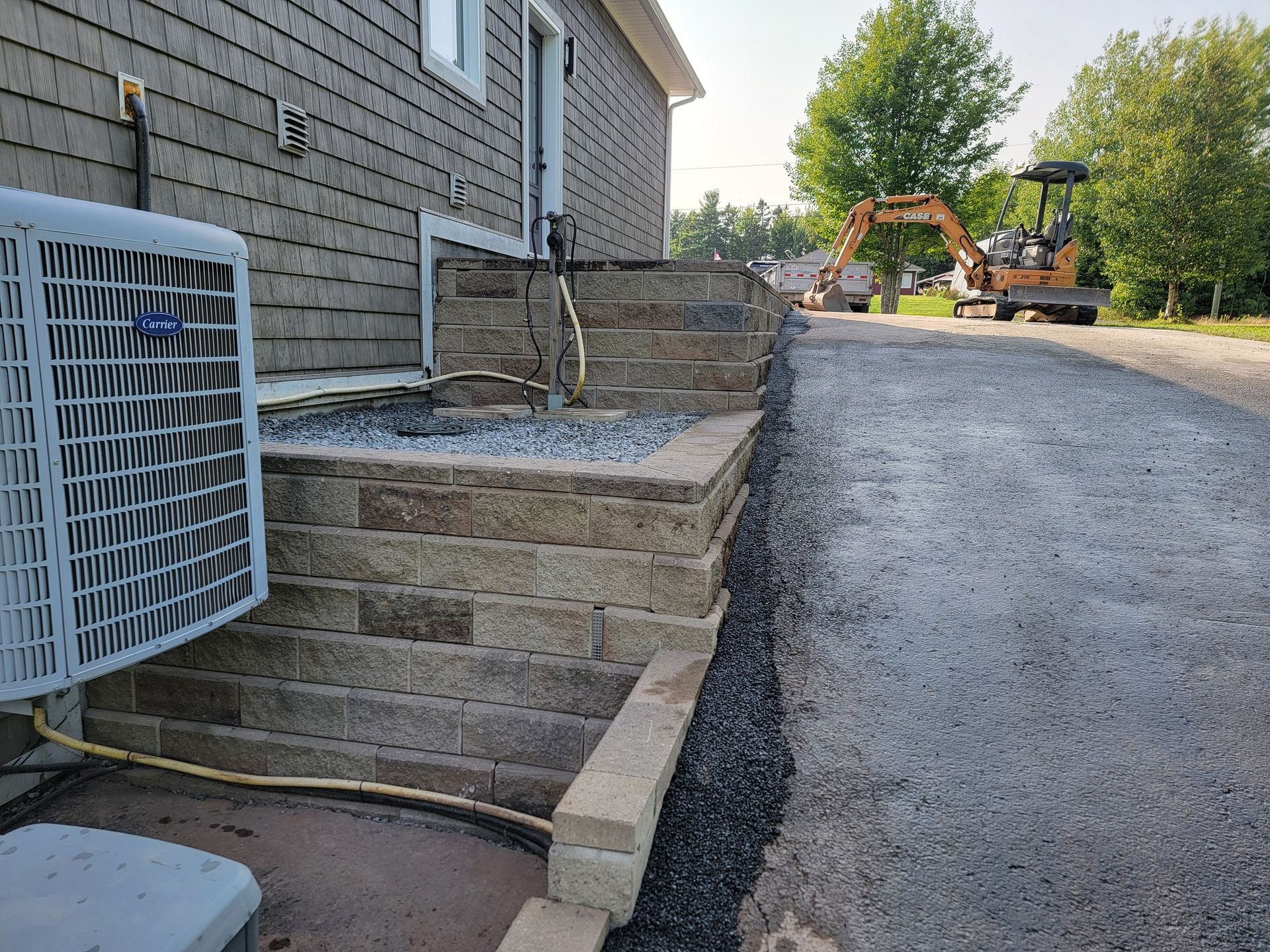 A brick wall is being built in front of a house.