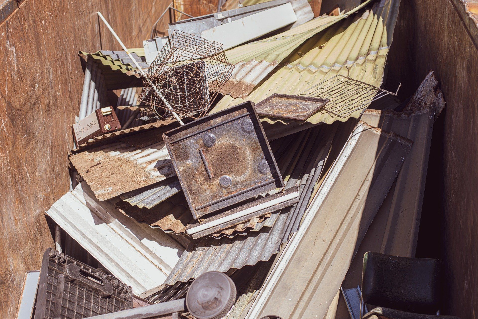A pile of scrap metal is sitting in a dumpster.