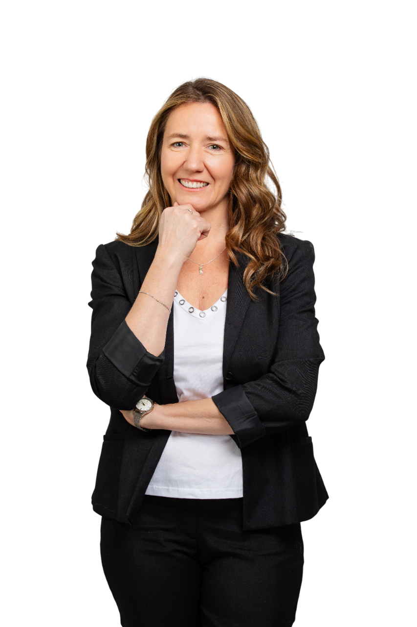 Mujer con blazer y vaqueros, sonriendo a la cámara. Sentada en un espacio interior, probablemente en un entorno profesional.