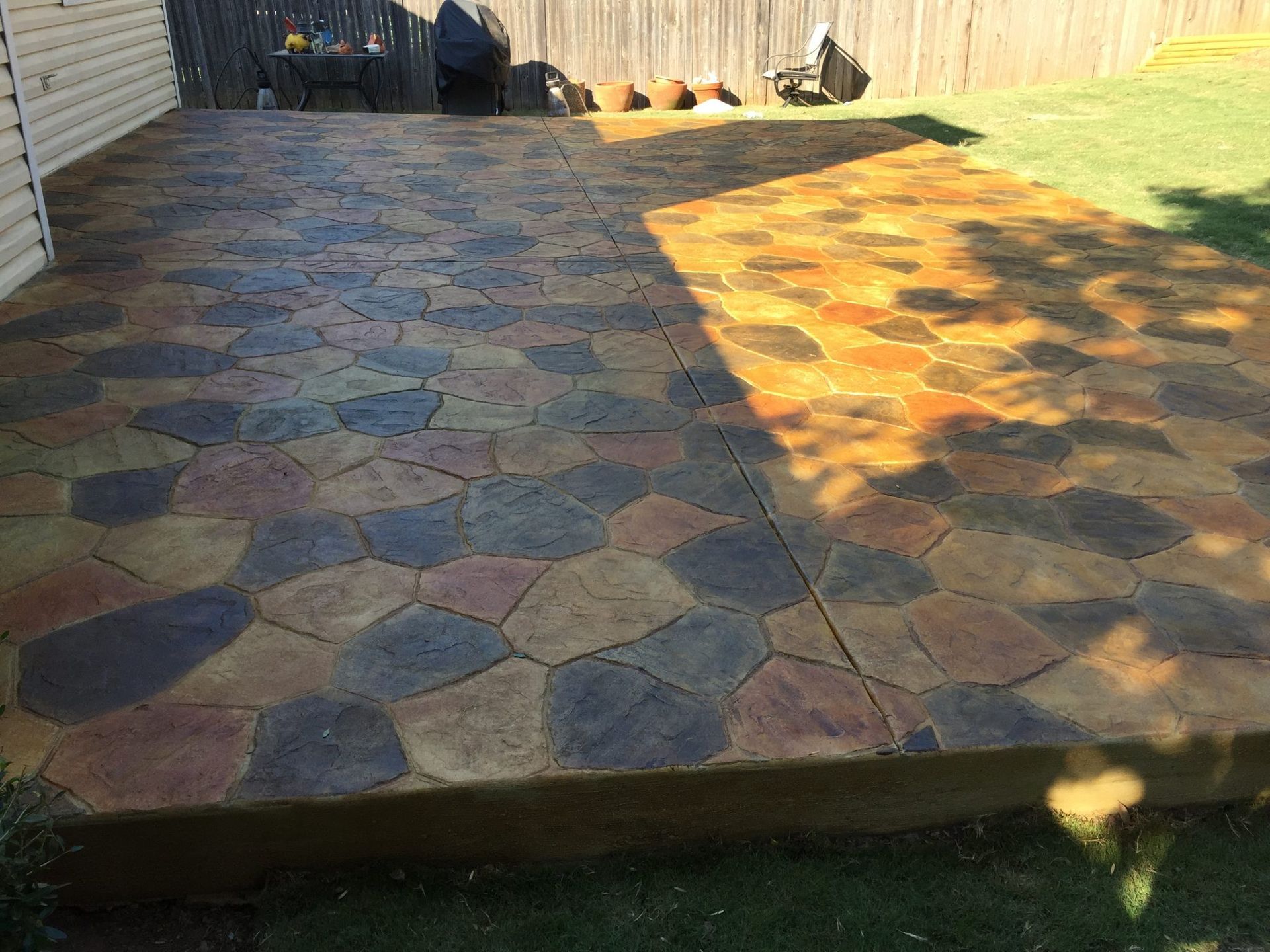 Stamped concrete patio with colorful stone pattern.