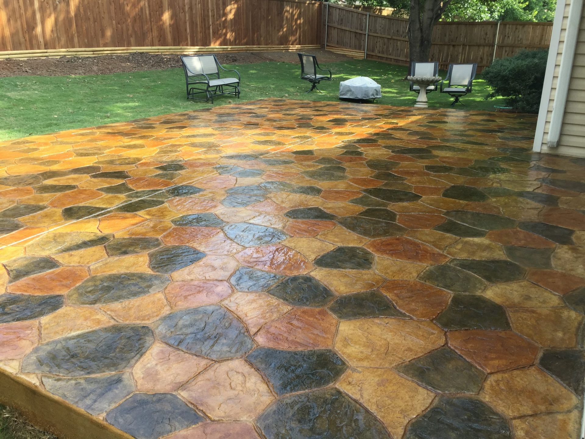 Stone-like stamped concrete patio with brown, black, and rust colored