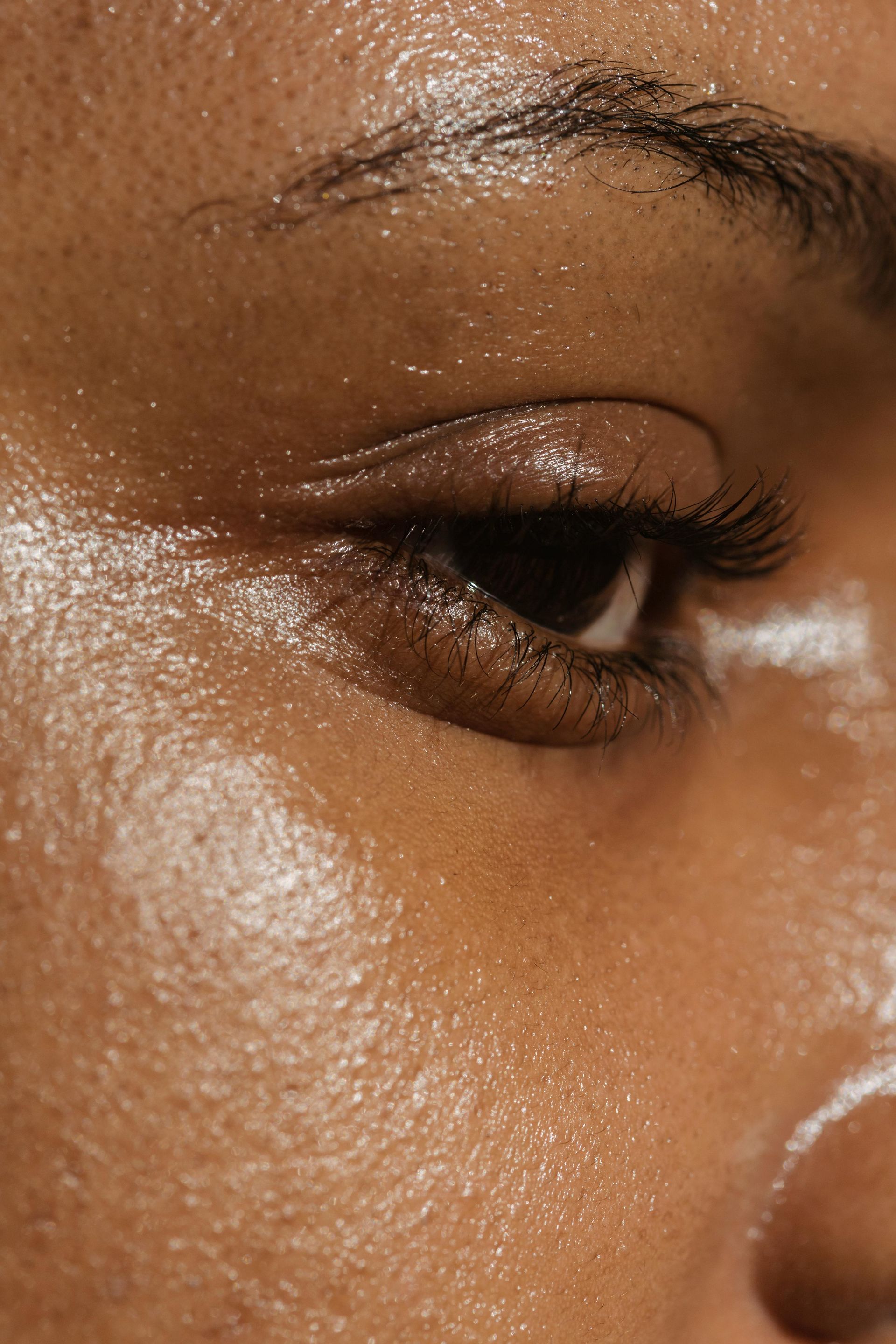 A close up of a woman 's face with sweat on it.