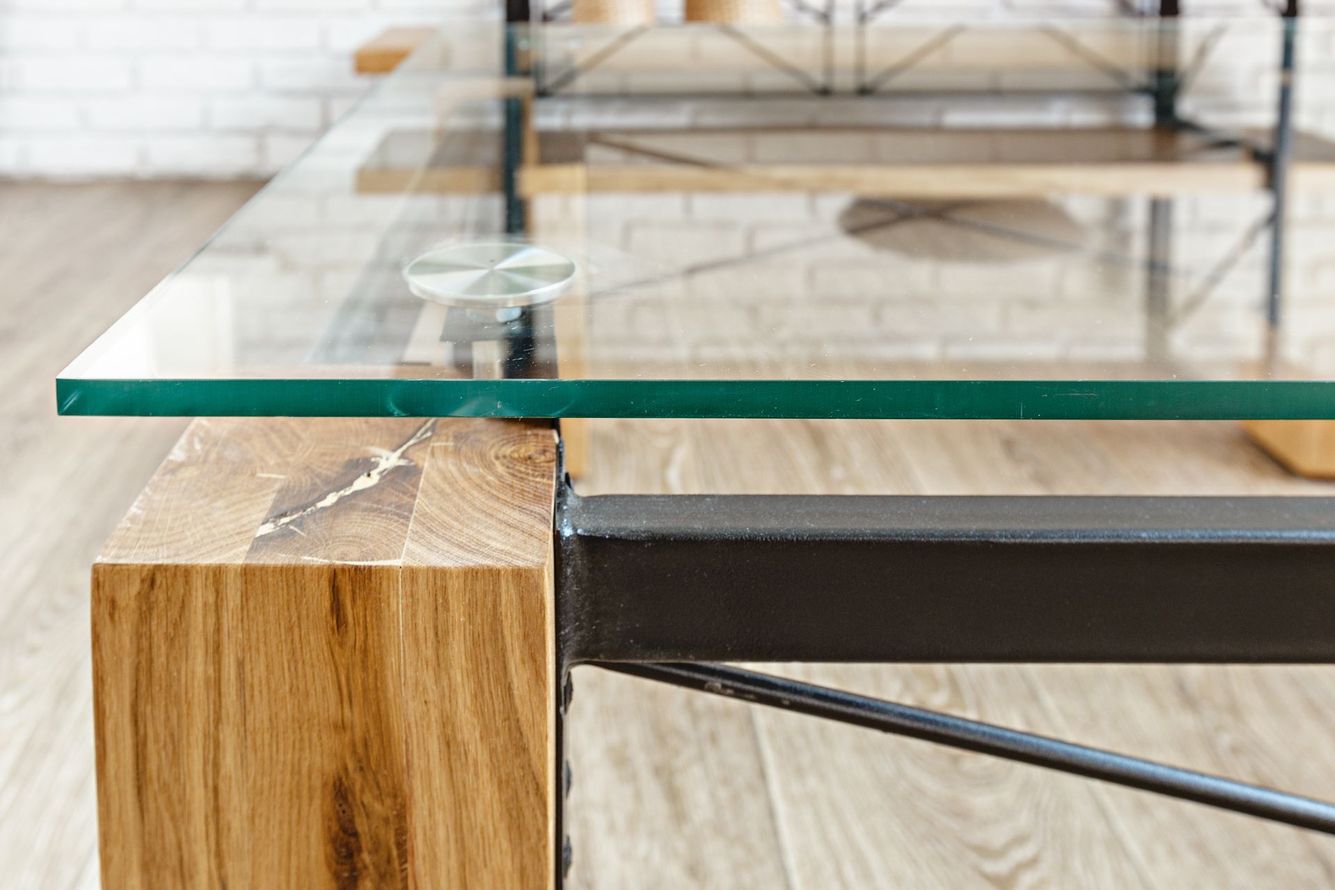 Glass tabletop on a wooden and black metal frame in a bright modern interior