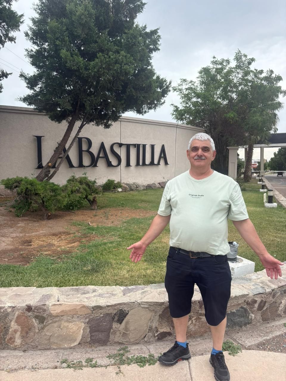 Hombre de pie frente a un cartel que dice 
