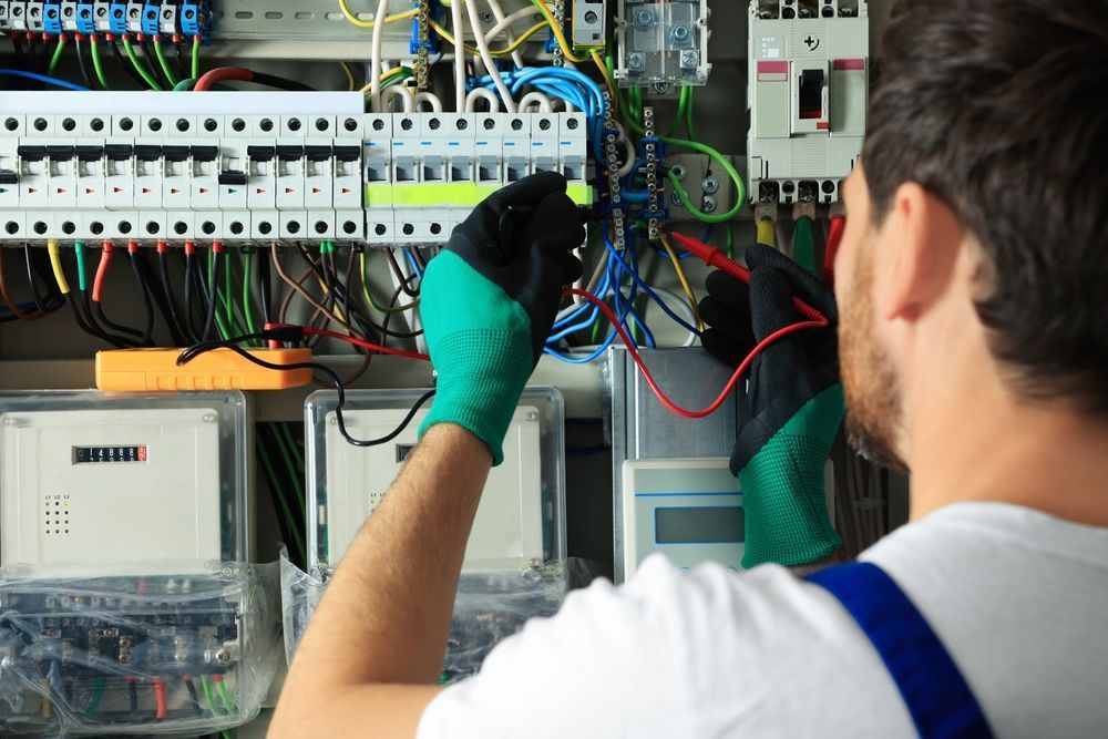 An electrician is working on an electrical panel.