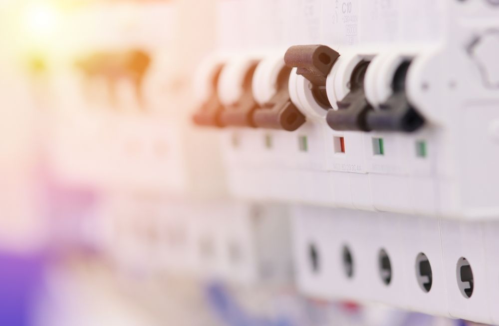 A close up of a row of electrical switches on a wall.